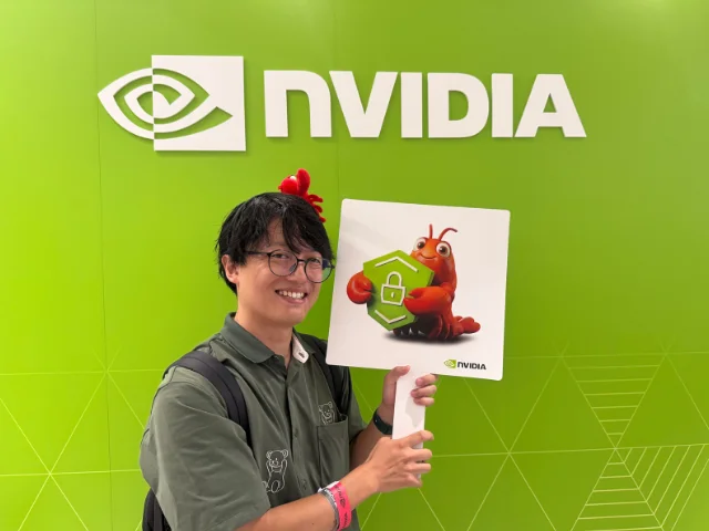 NVIDIAロゴの前でOpenClawのパネルを持つ筆者